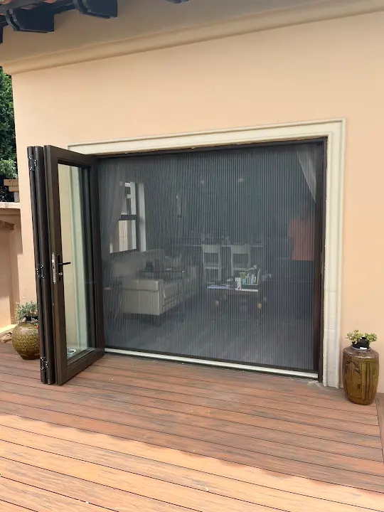 Wide pleated screen across a folding patio opening