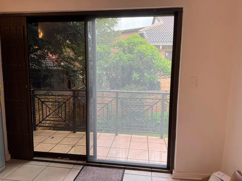 Pleated screen fitted to a sliding balcony door